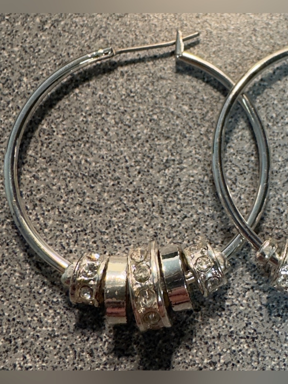 Silver-tone hoops with multiple dangling  crystal-encrusted charms or rondelles.